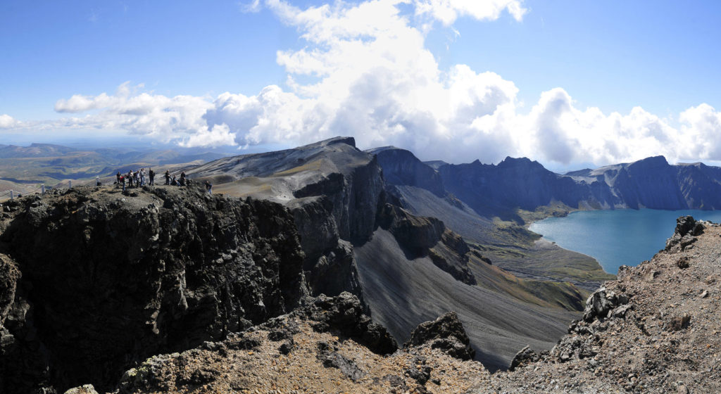 Tourists standing at the crater rim of Heaven Lake of Mt. Paektu